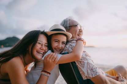 A grandfather and granddaughters having fun on the beach.