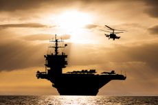 Aircraft carrier at sunset in the sea