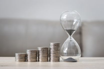 hourglass next to stacks of coins