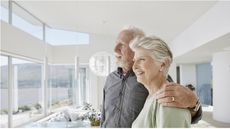 A retired couple gaze out the window.